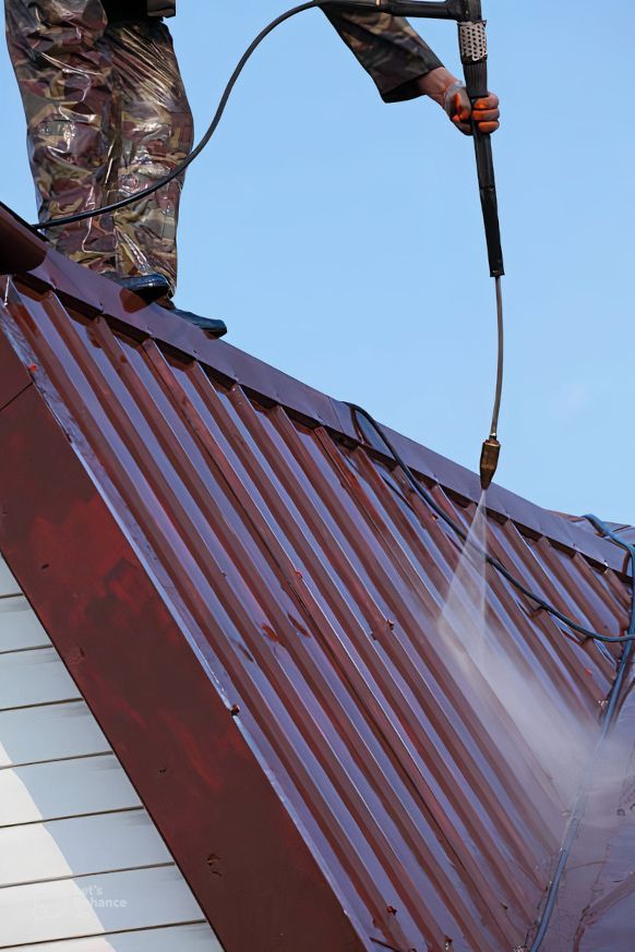 A man is spraying a roof with a soft pressure washer. Expertly cleaning moss from the roof in Stoke-on-Trent.