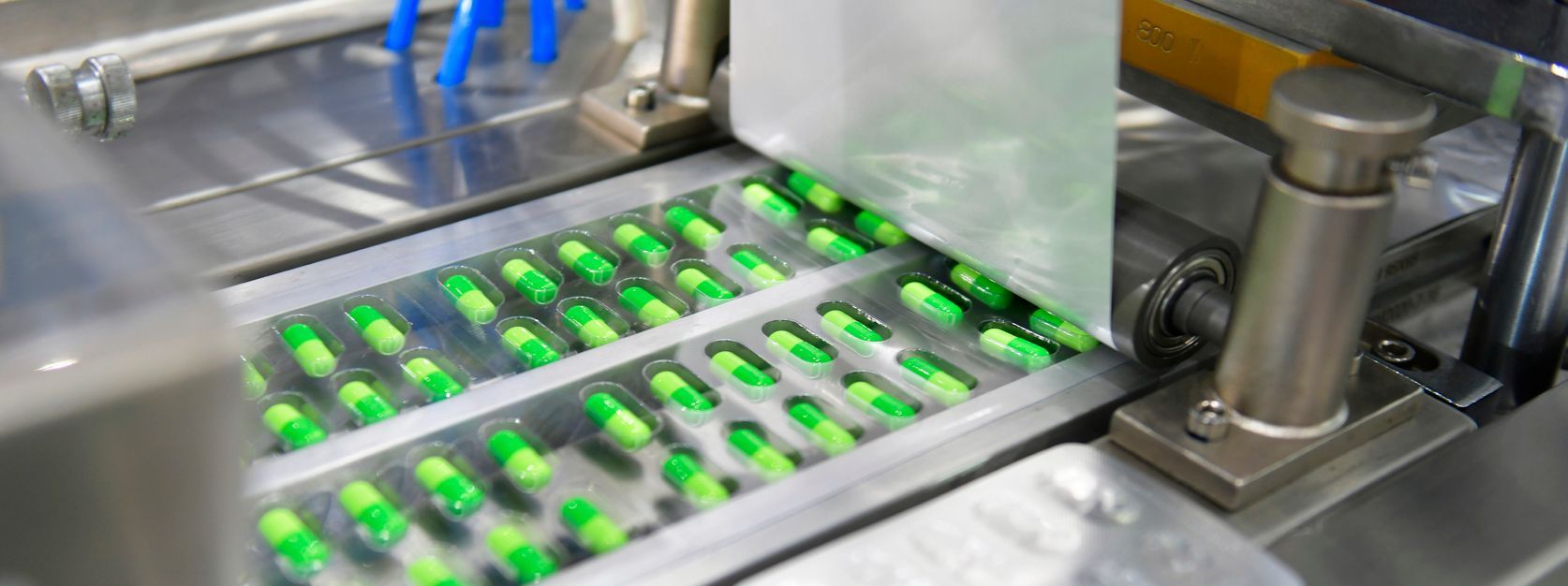 Close-up of metallic industrial machinery with multiple cylinders and complex gears.