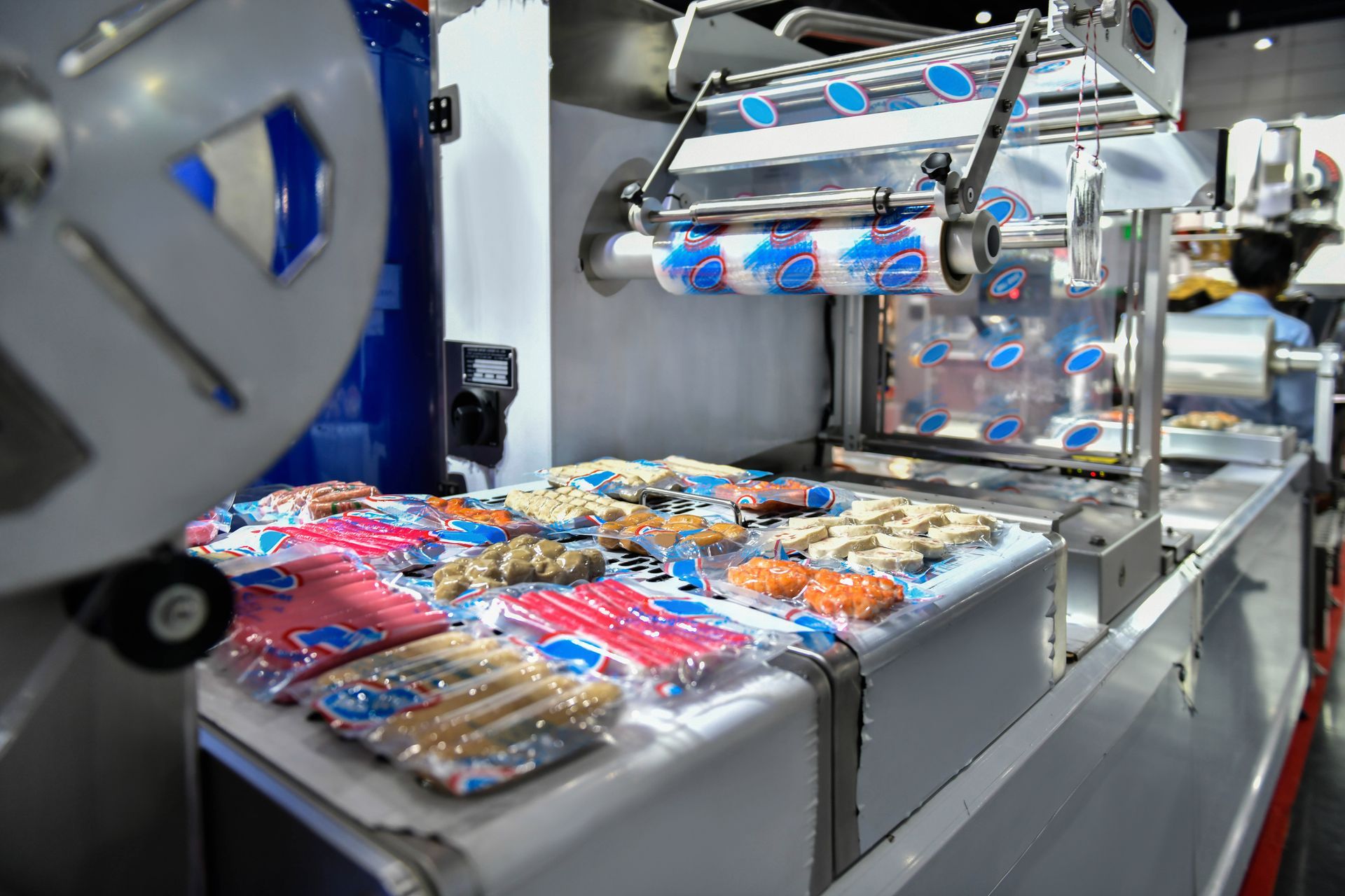 Automated packaging machine wrapping food items in plastic.