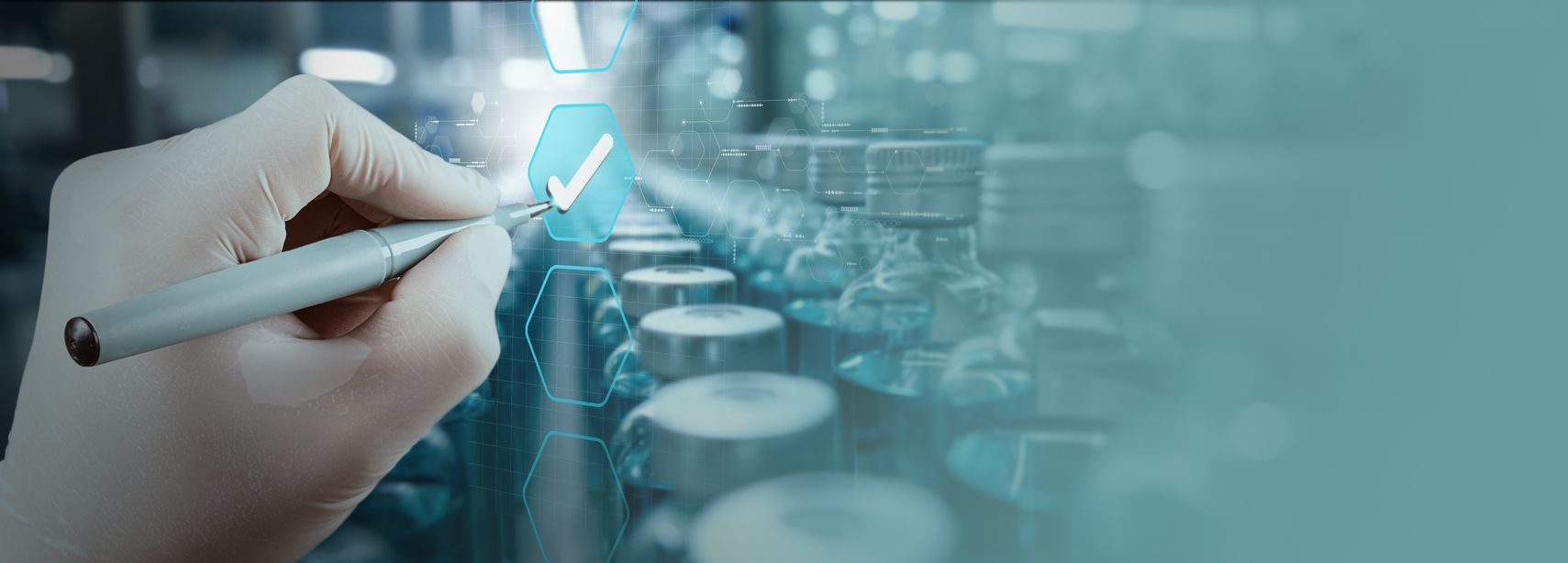 Industrial stainless steel processing equipment in a cleanroom environment. Pipes, tanks, and machinery are visible.