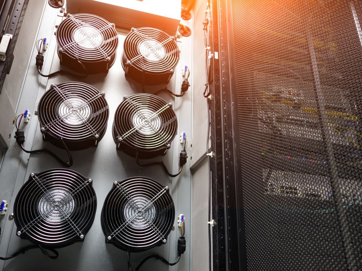 Overhead view of an industrial complex with buildings, tanks, parking, and green areas.