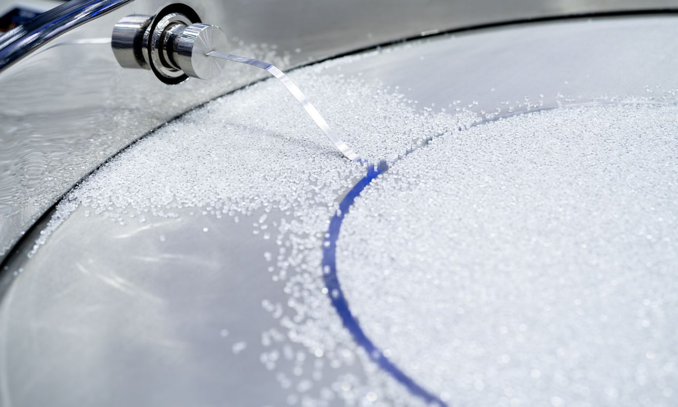 Close-up of metallic industrial machinery with multiple cylinders and complex gears.