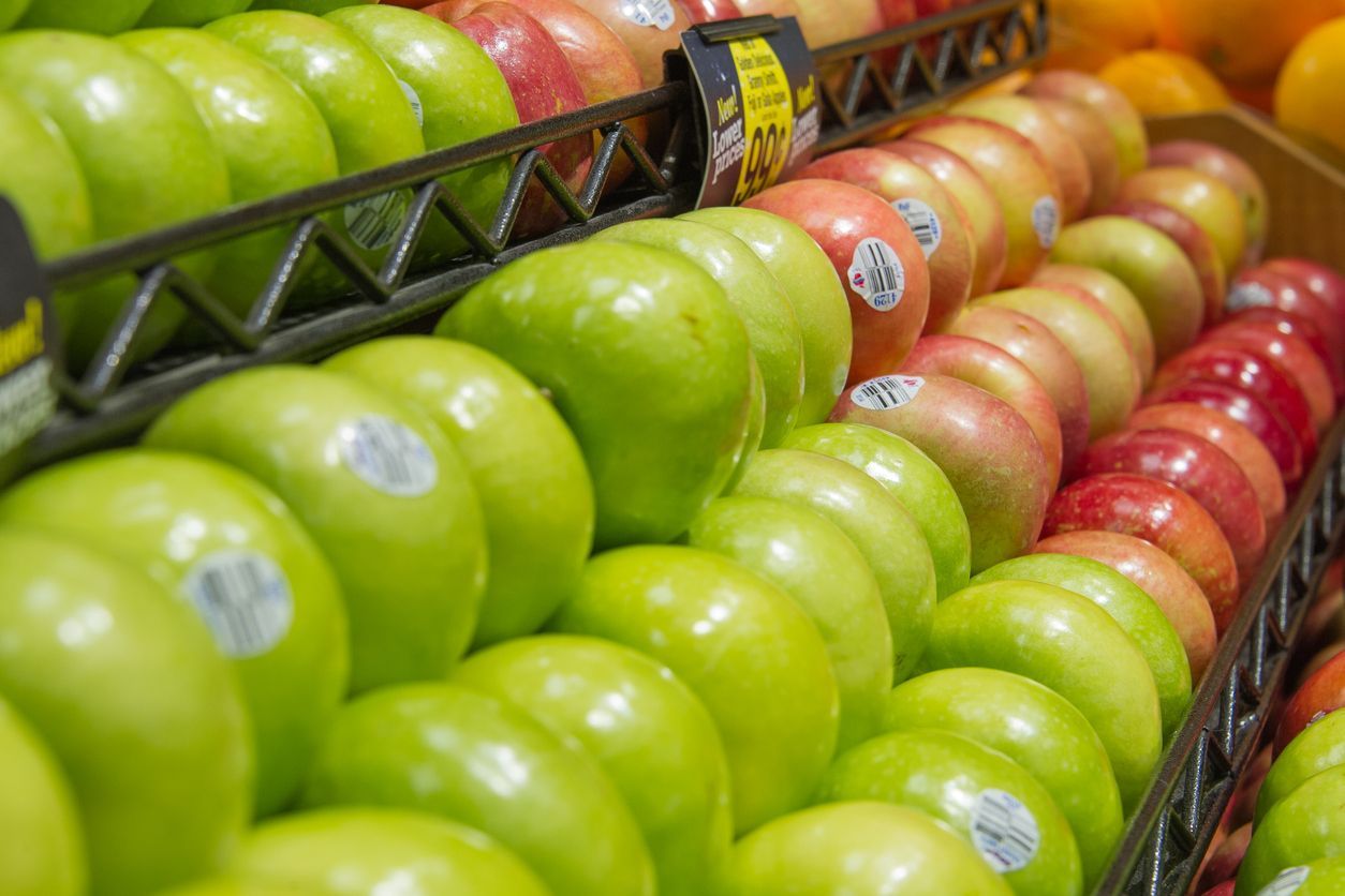 Overhead view of an industrial complex with buildings, tanks, parking, and green areas.