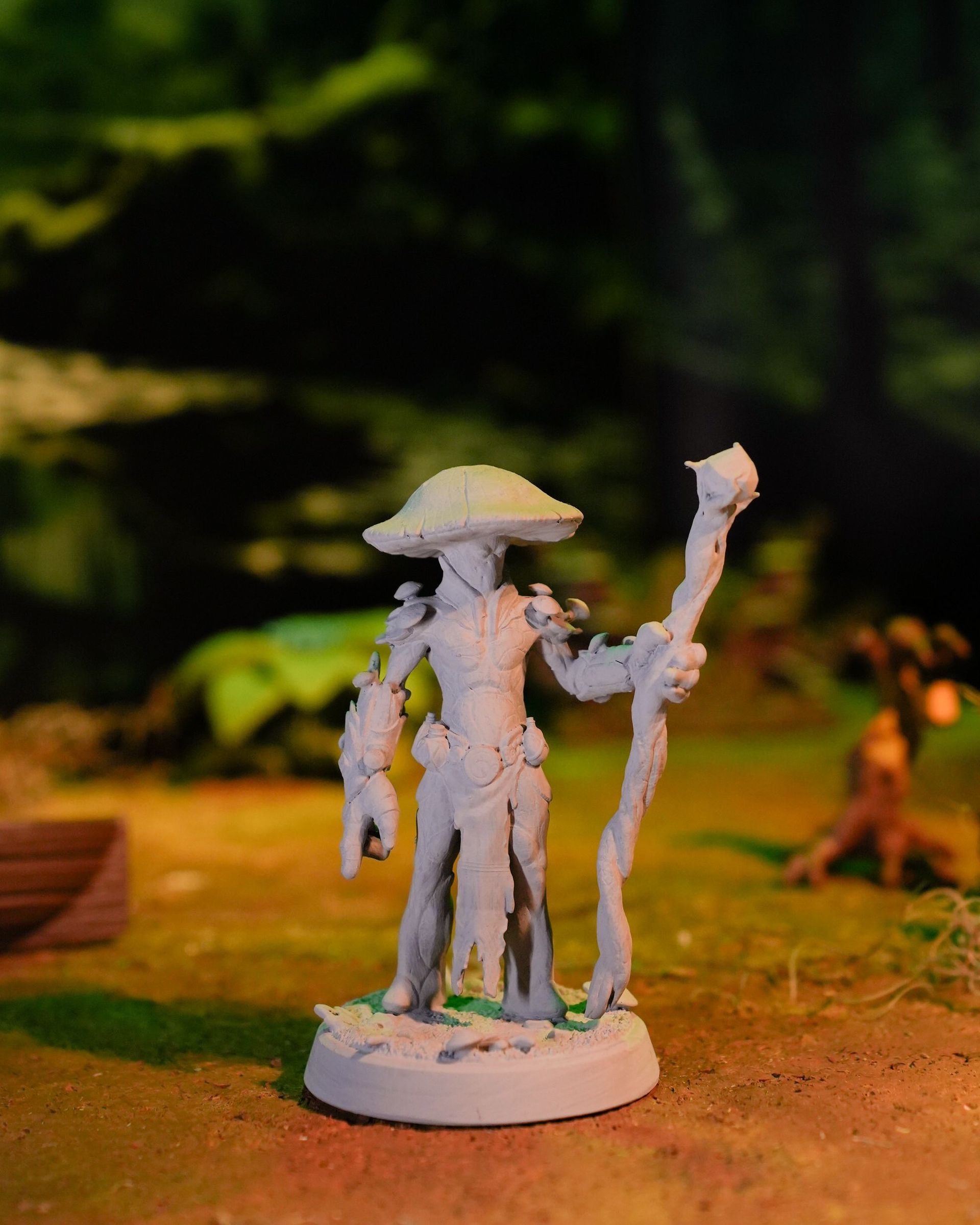A statue of a man with a mushroom hat and a cane.