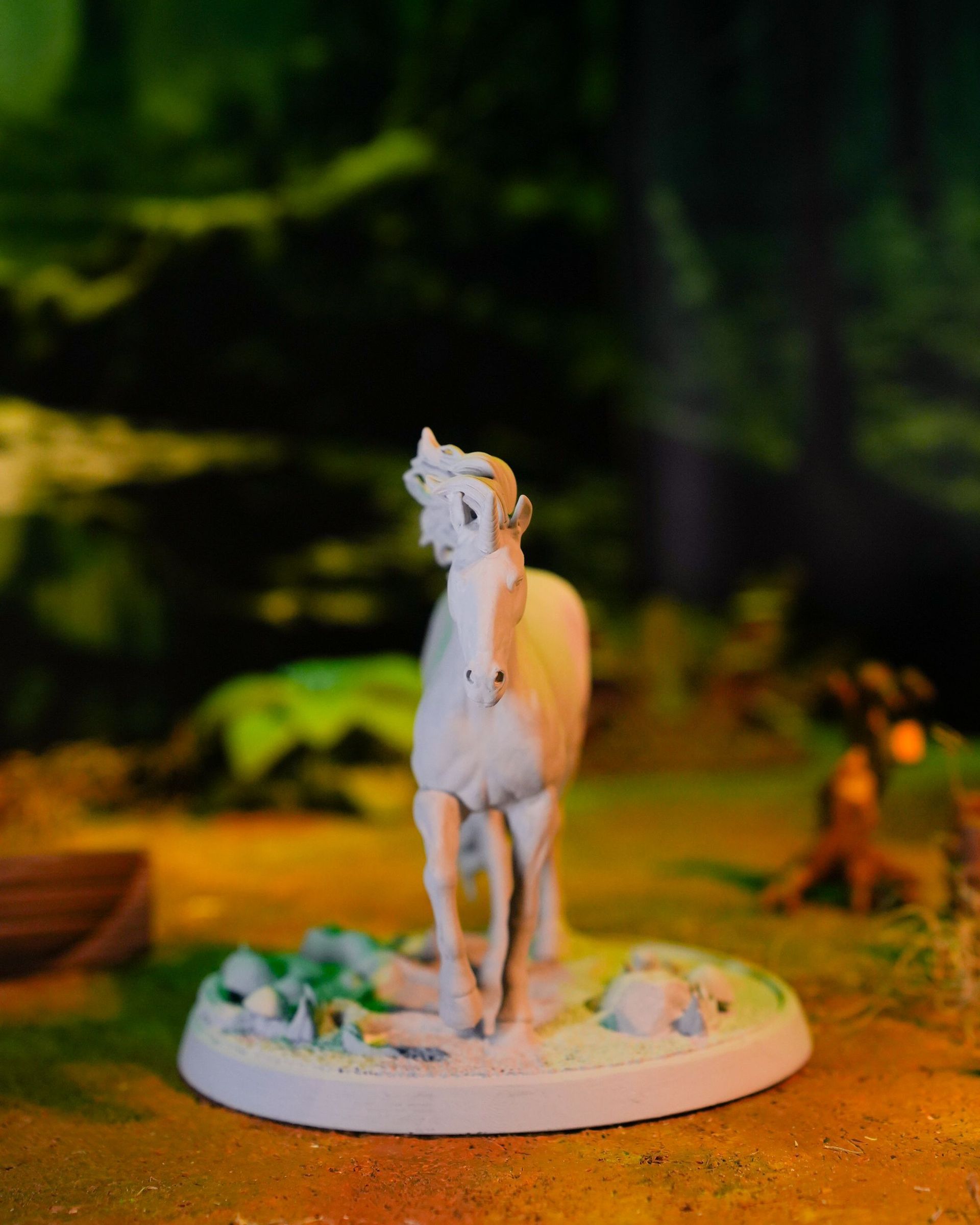 A statue of a white unicorn standing in the grass