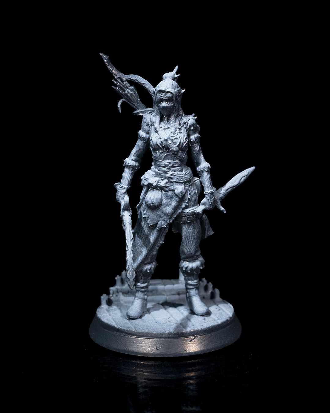 A statue of a woman holding two swords and a shield.