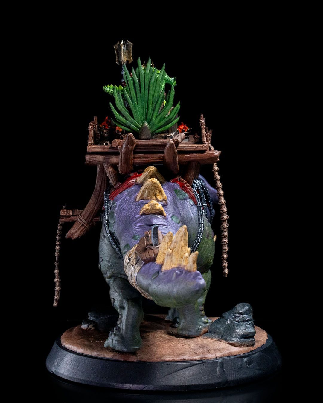 A statue of a man riding on the back of a dinosaur.