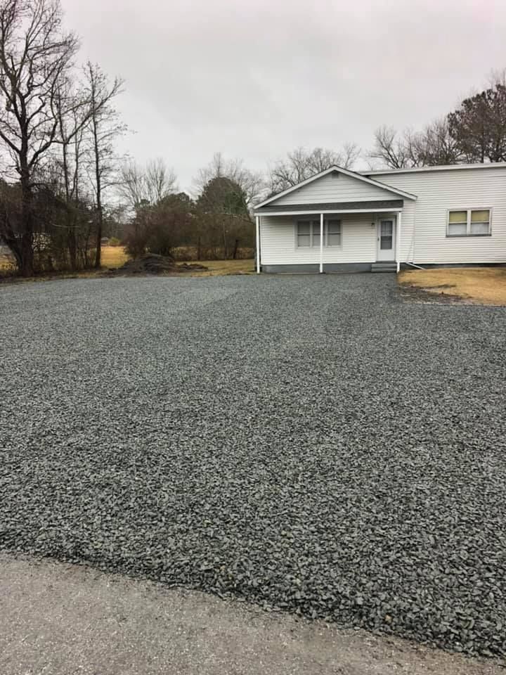 A house with a gravel driveway on a cloudy day.