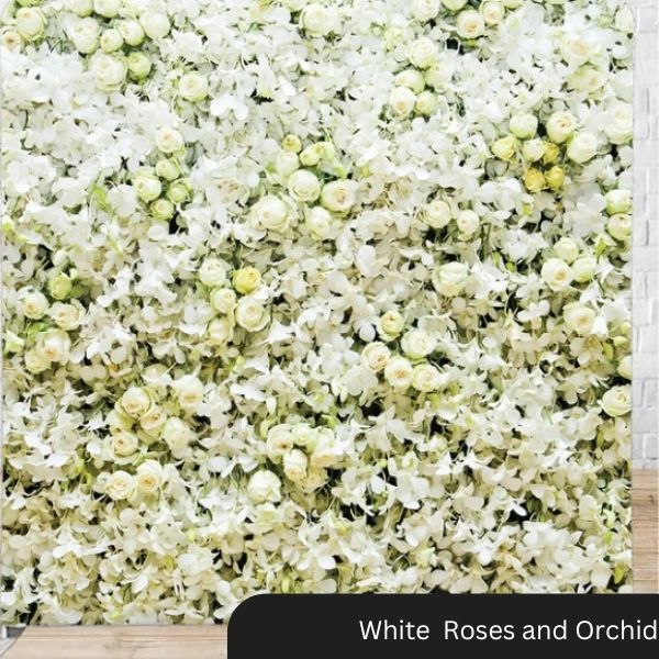 A wall of white roses and orchids on a brick wall