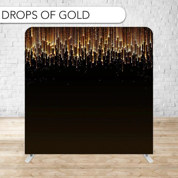 A black and gold backdrop is sitting on a wooden floor in front of a brick wall.