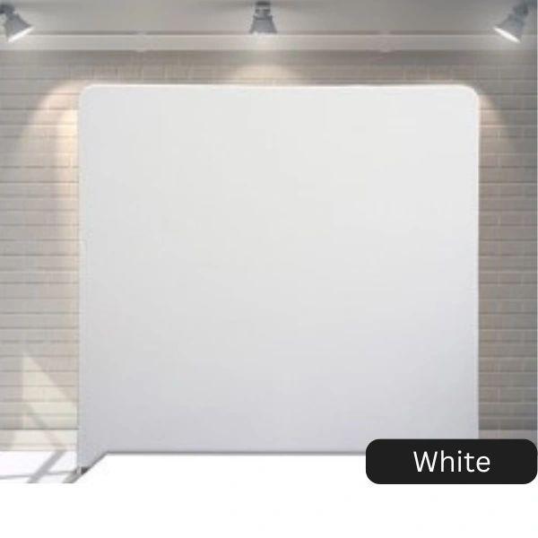A white backdrop is sitting in front of a brick wall.