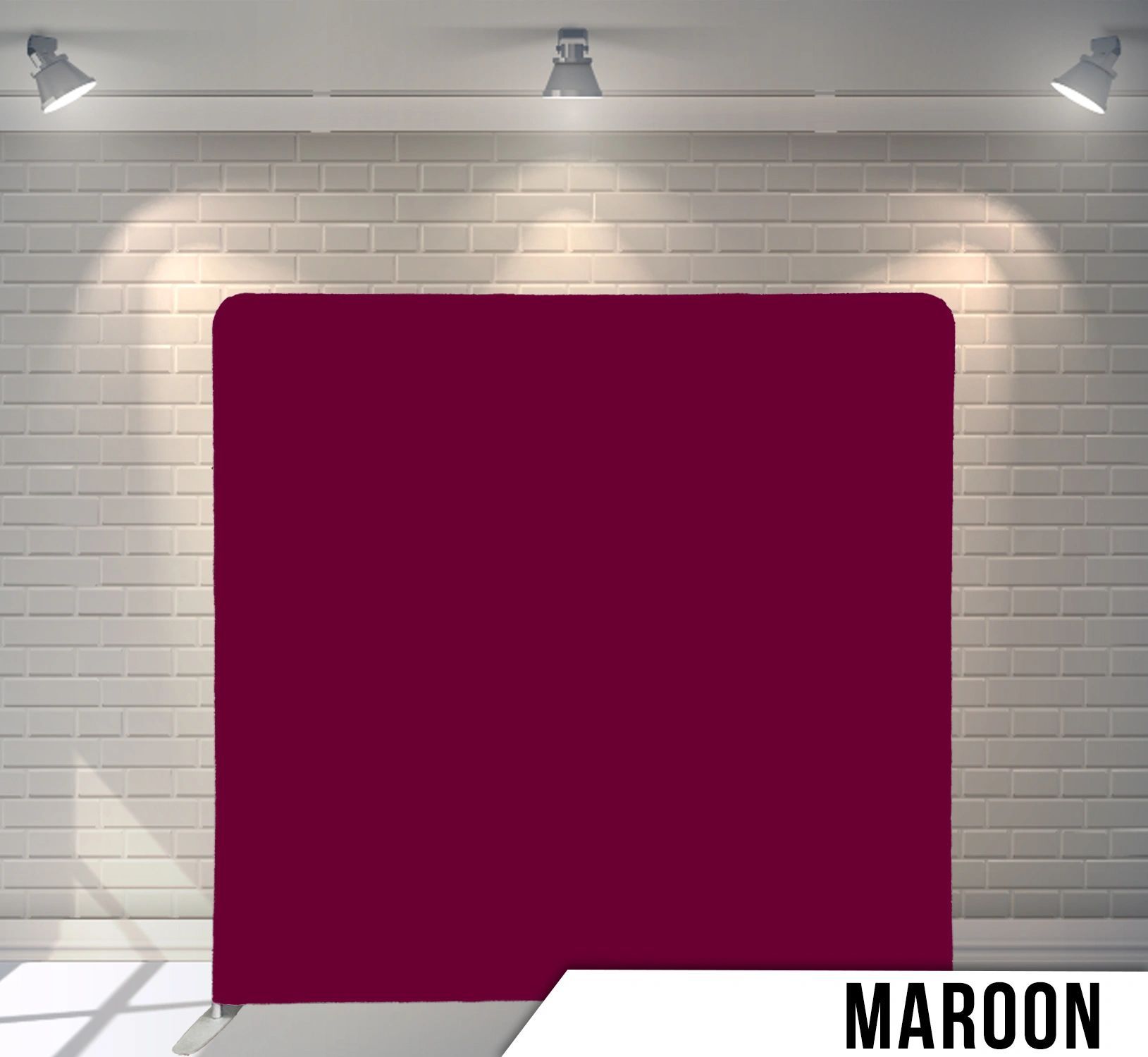 A maroon square is sitting in front of a white brick wall.
