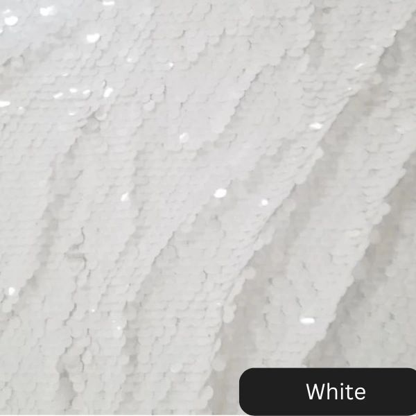 A white sequined fabric with a black label that says white