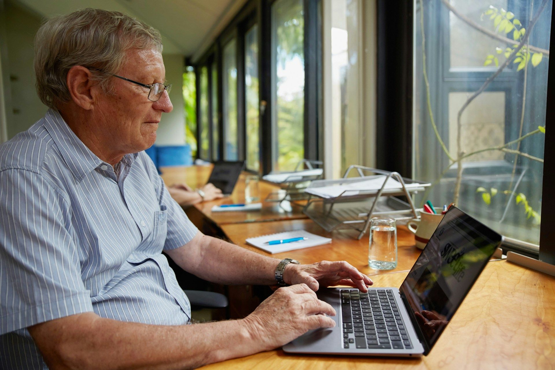 Homem aposentado que continua trabalhando olha para notebook