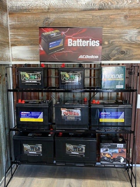 Black metal display rack with various car batteries. 