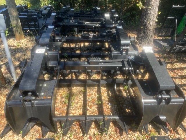 Black grapple attachment for a tractor, with sharp teeth.