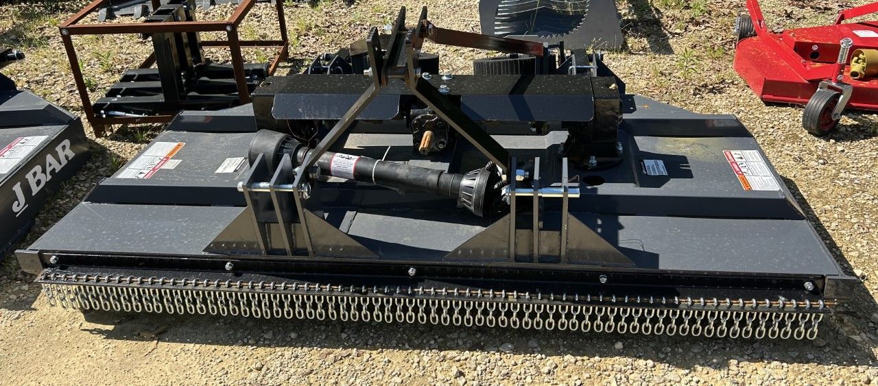 Black industrial mower with blades, angled metal supports, and connecting shaft, outdoors.