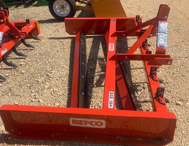 Red Befco landscape rake on gravel.