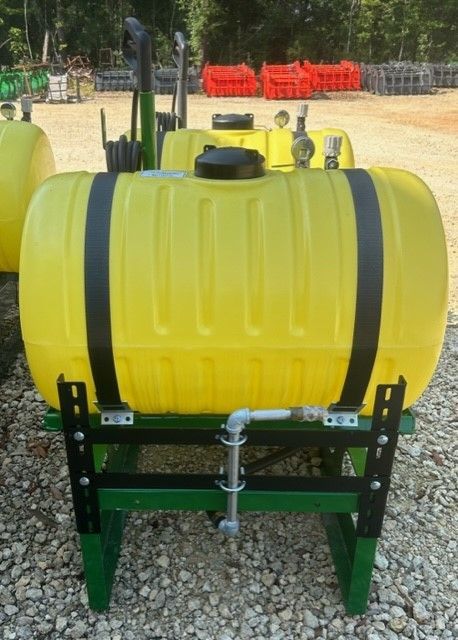 Yellow tank sprayer on a green frame, outdoors.