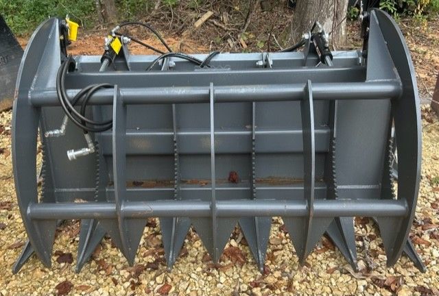 Gray grapple bucket for a skid steer, designed for picking up debris.