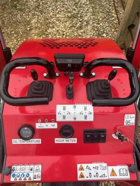 Red control panel with black joysticks, gauges, and switches.