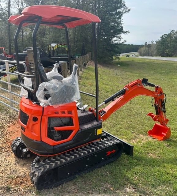 Orange and black compact excavator on tracks, outdoors with a red canopy.