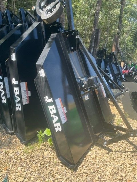 Black J Bar metal implements stacked outdoors.