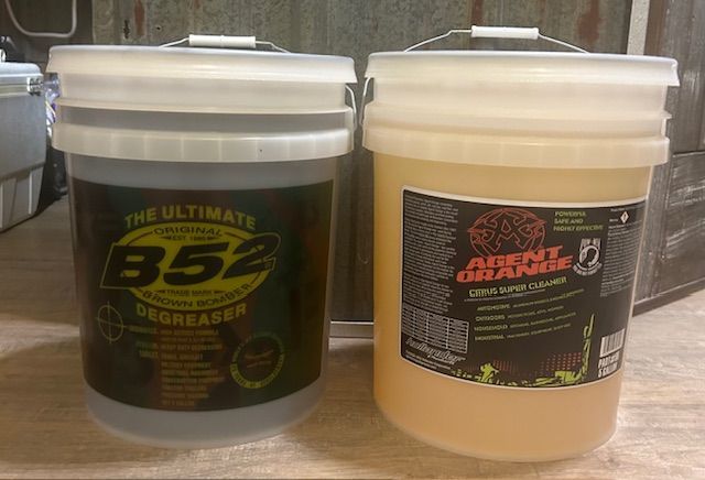 Two 5-gallon buckets of cleaning products: B52 Degreaser (dark liquid) and Agent Orange Cleaner (light liquid).