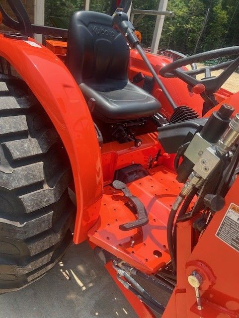 Orange tractor with black seat and large tires.