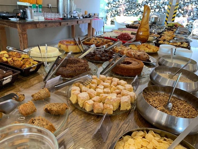 Mesa de bufê com diversos produtos de panificação, cereais e condimentos.