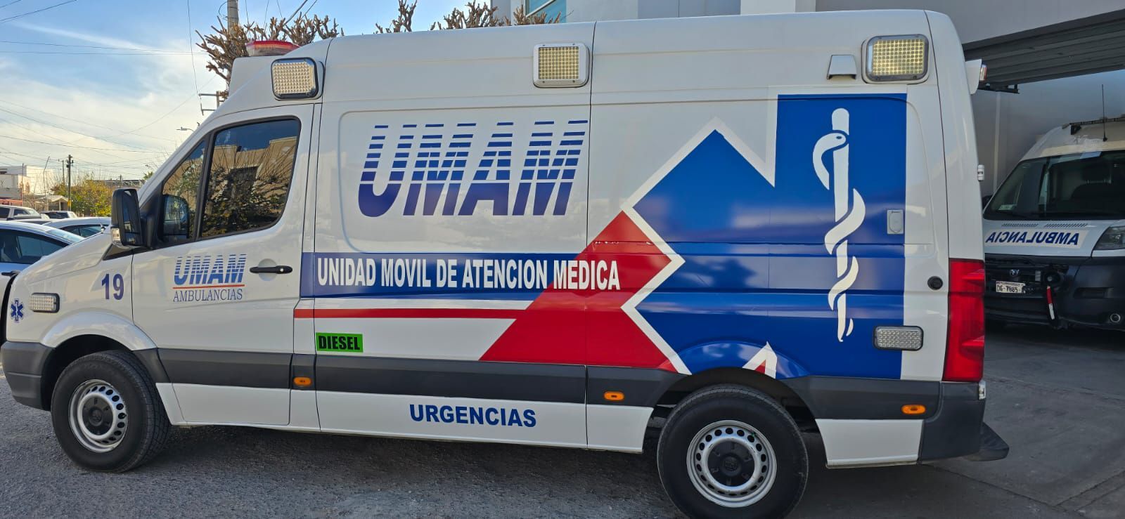 Ambulancia blanca y azul con las letras 