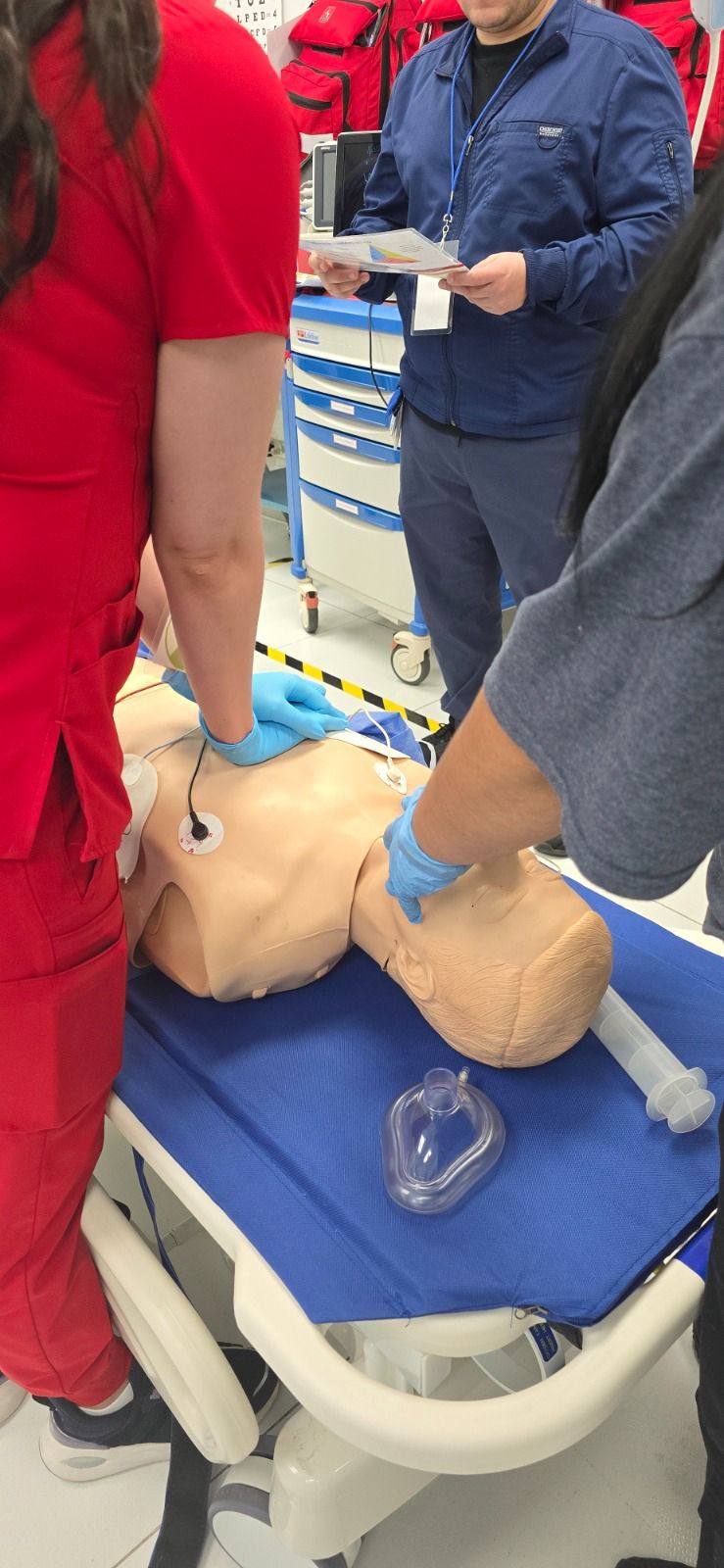 Personas practicando RCP con un maniquí médico. Están en un entorno de entrenamiento.