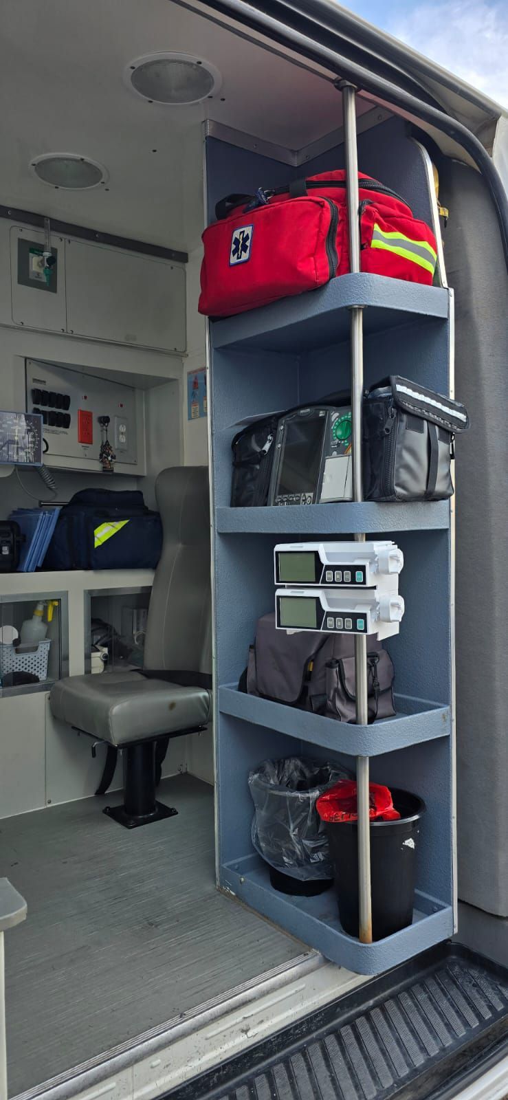 Interior de una ambulancia con estantes que contienen suministros médicos.