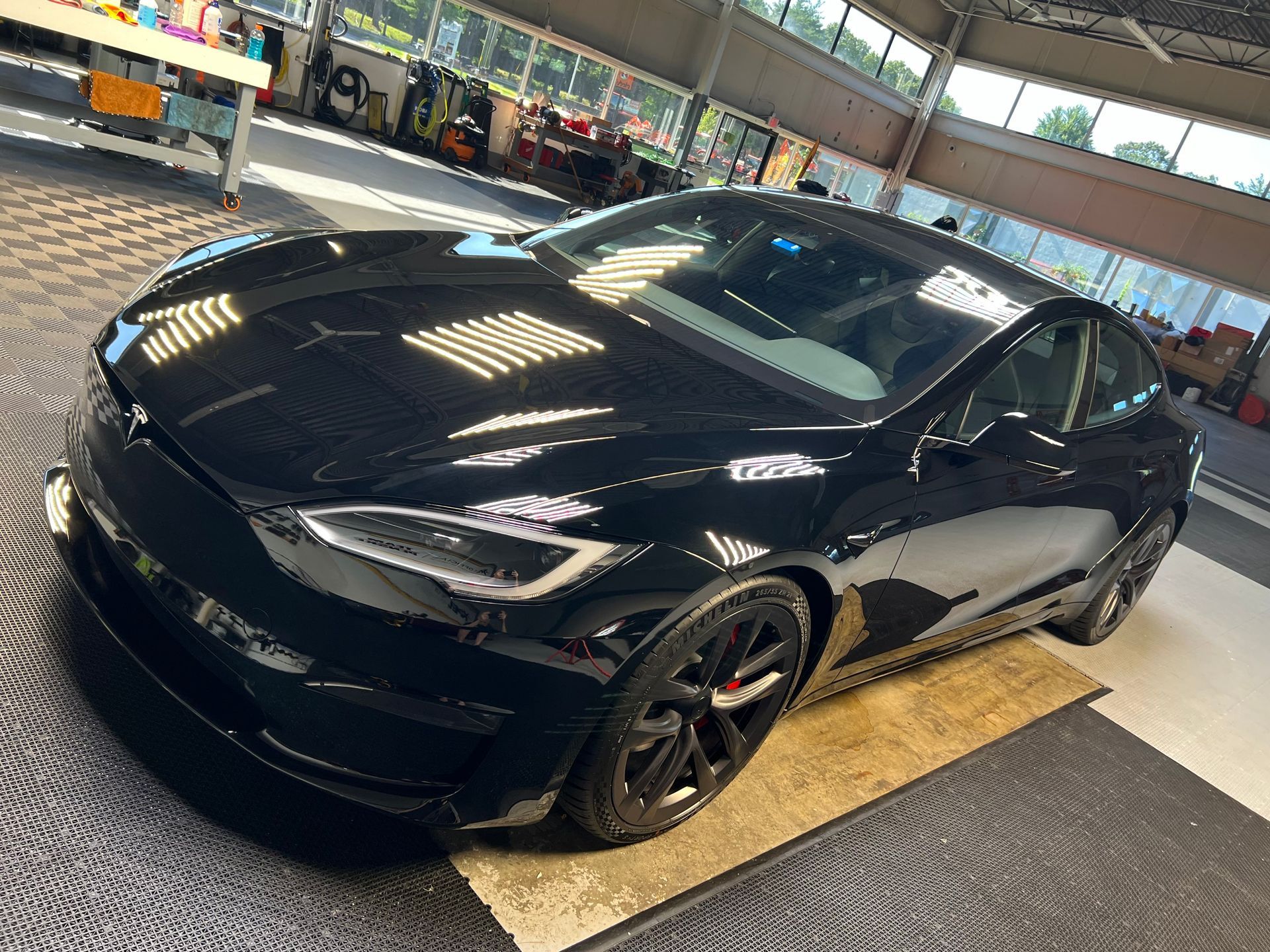 A black tesla model s is parked in a garage.