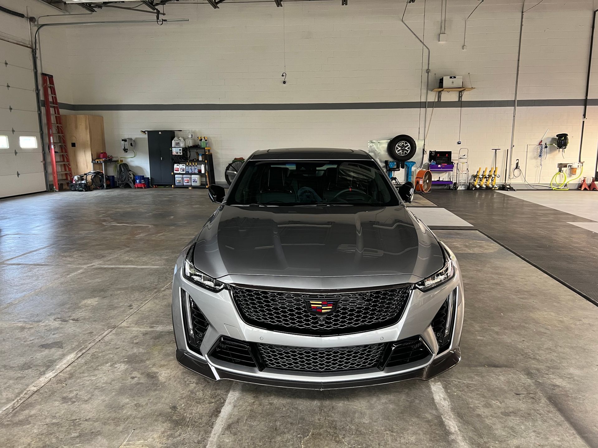 Silver Cadillac sedan parked in a garage.