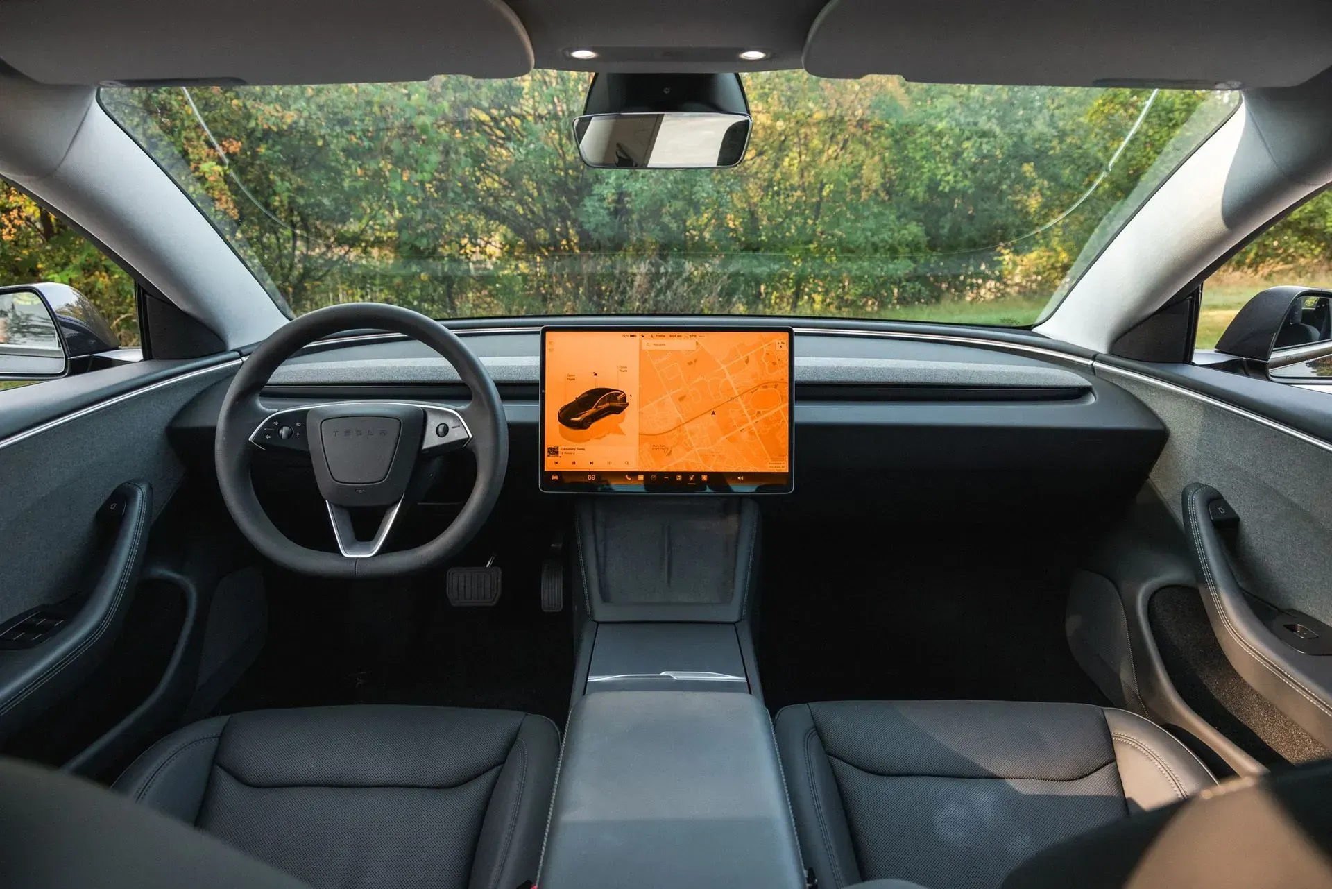 The interior of a tesla model s with a tablet on the dashboard.