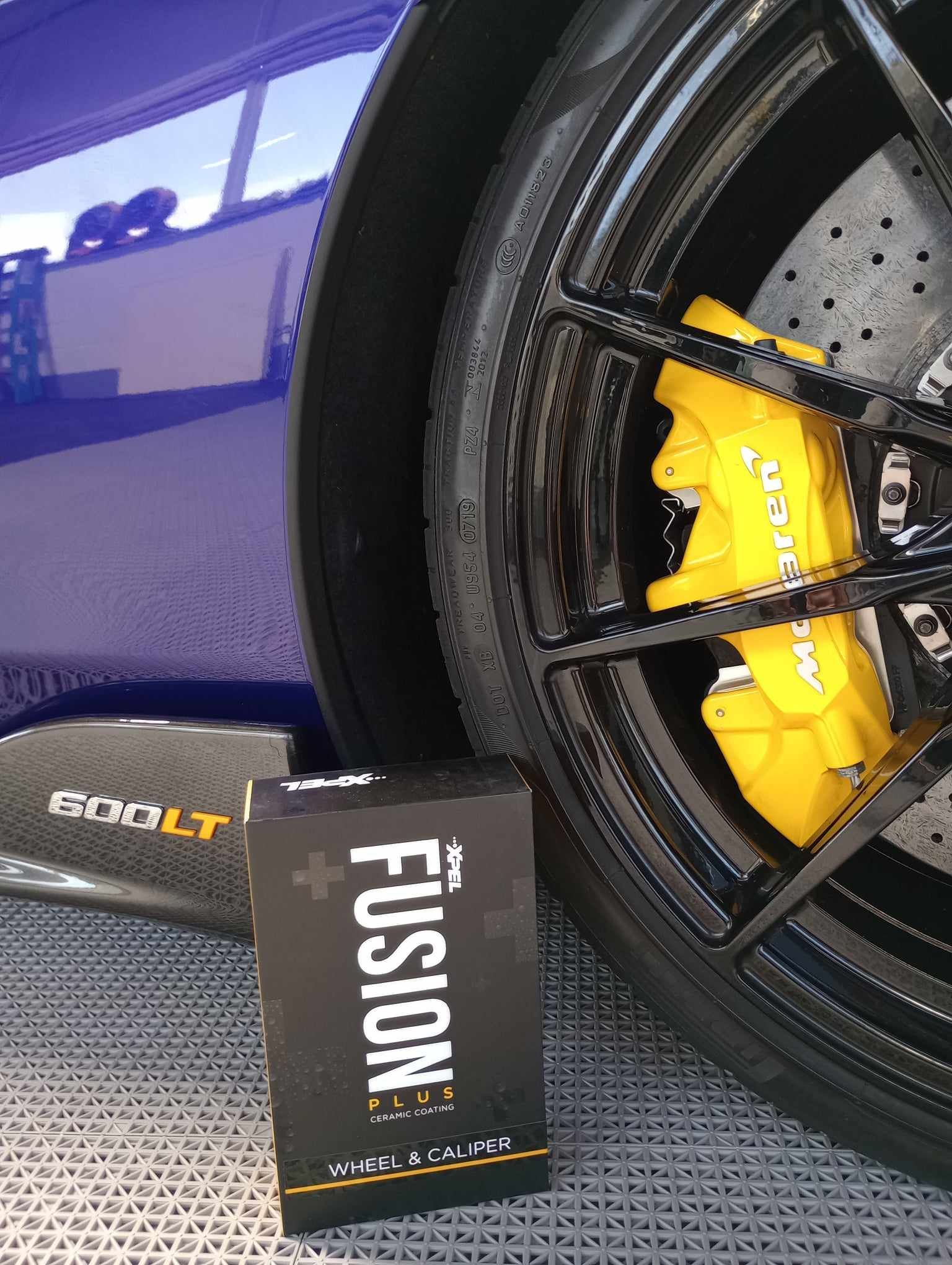 A close up of a car wheel with a yellow brake caliper