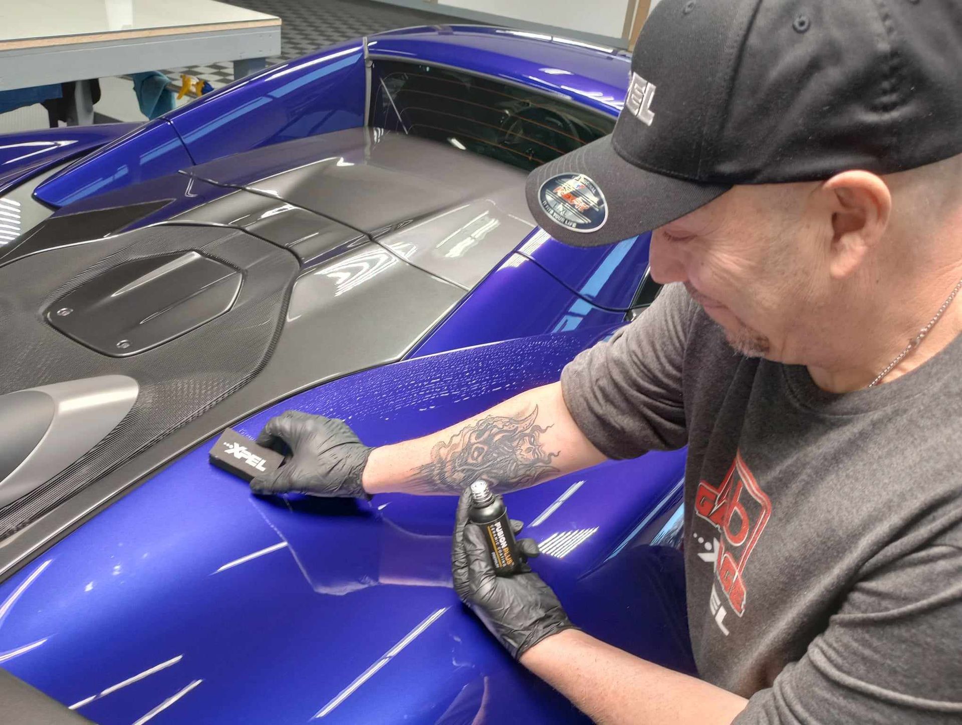 A person is wrapping a car with clear plastic