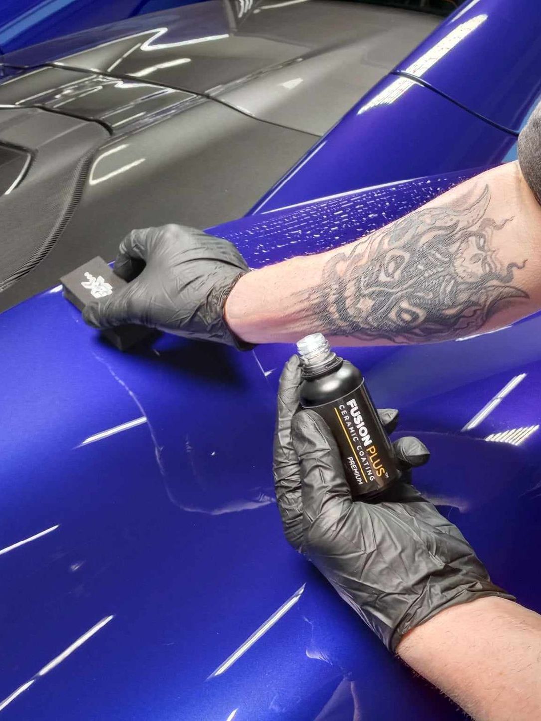 A car is covered in plastic wrap in a garage.