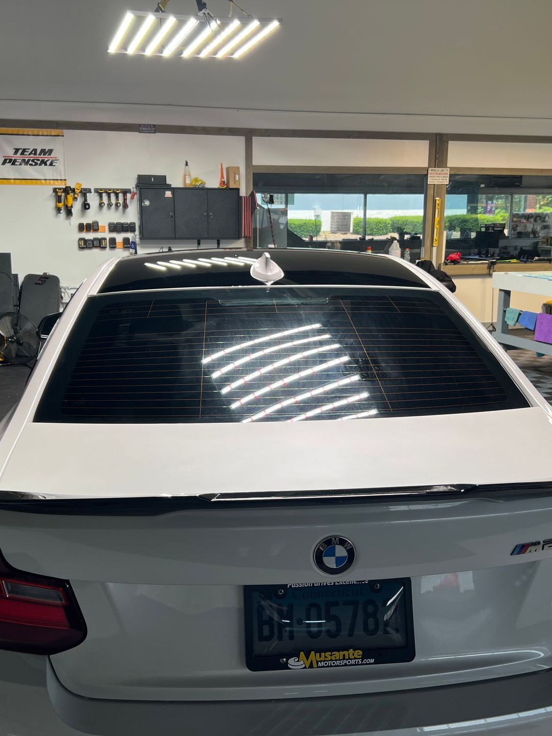 A white bmw is parked in a garage.