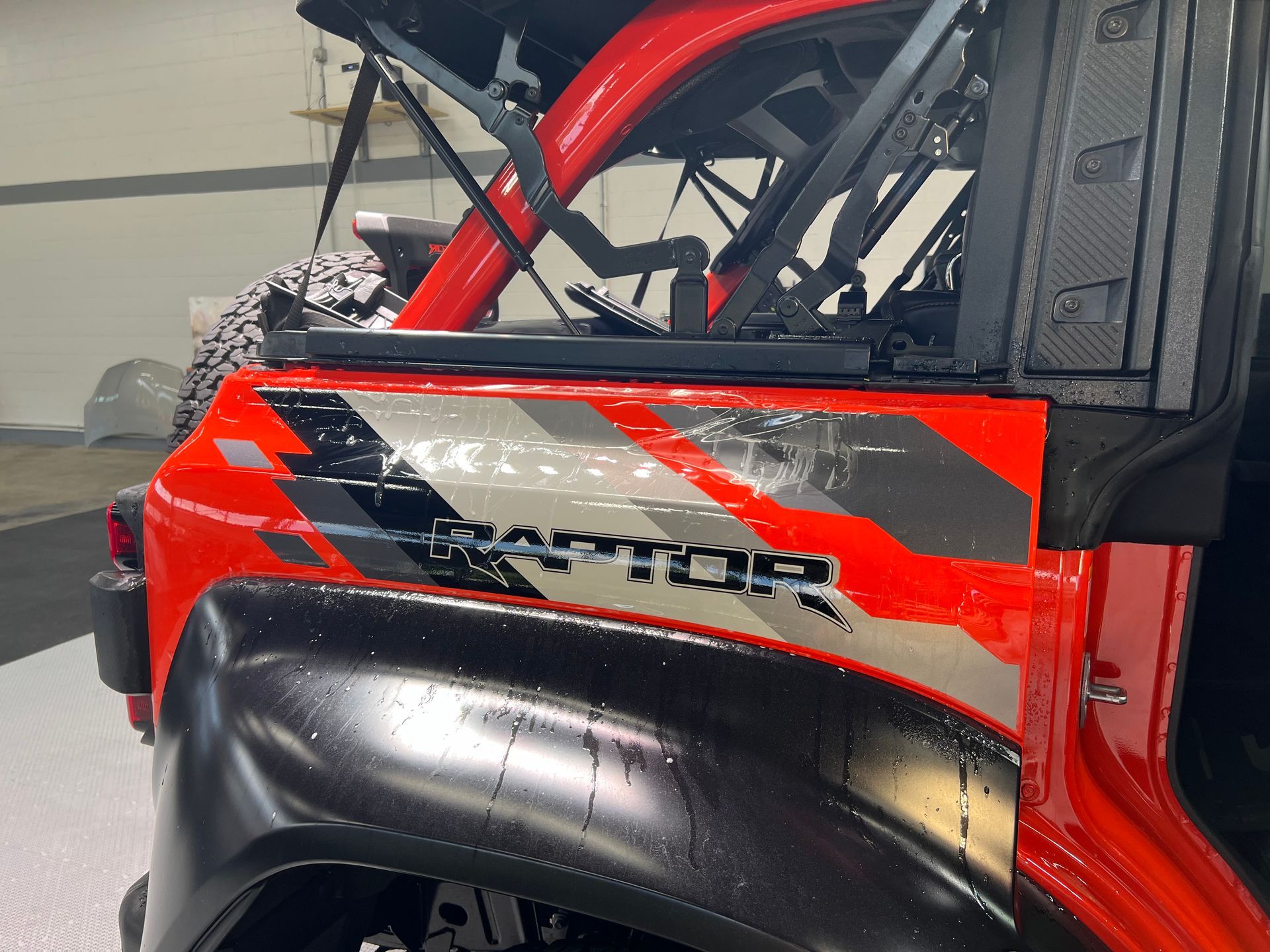 A red jeep with the word raptor on the side