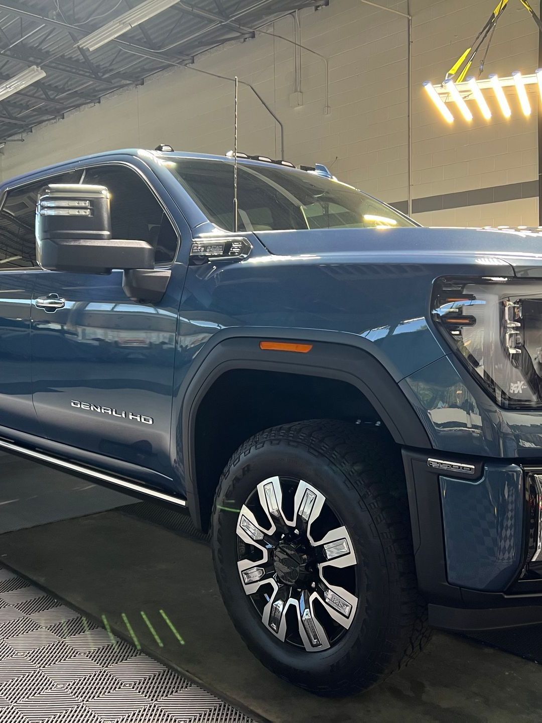 A person is washing a car wheel with foam