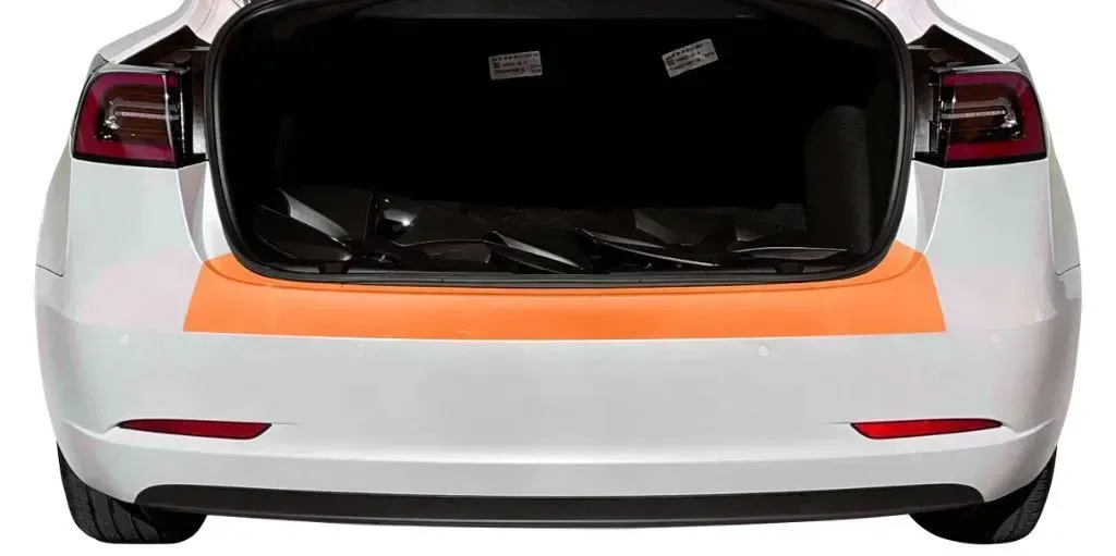 The back of a white tesla model 3 with the trunk open.