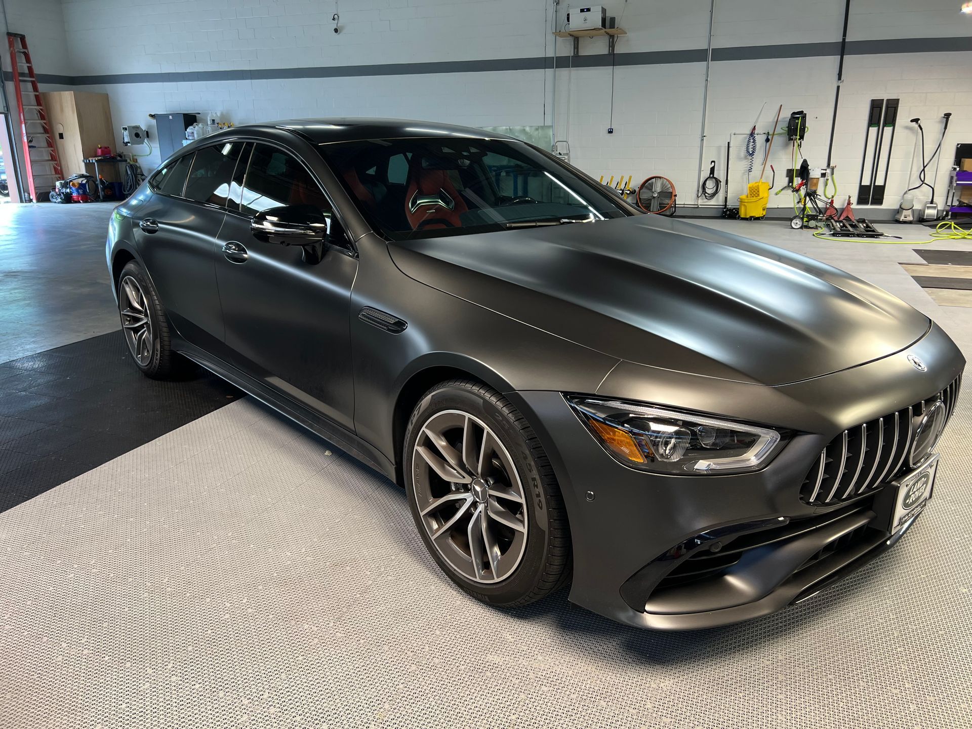 A black mercedes benz is parked in a garage.
