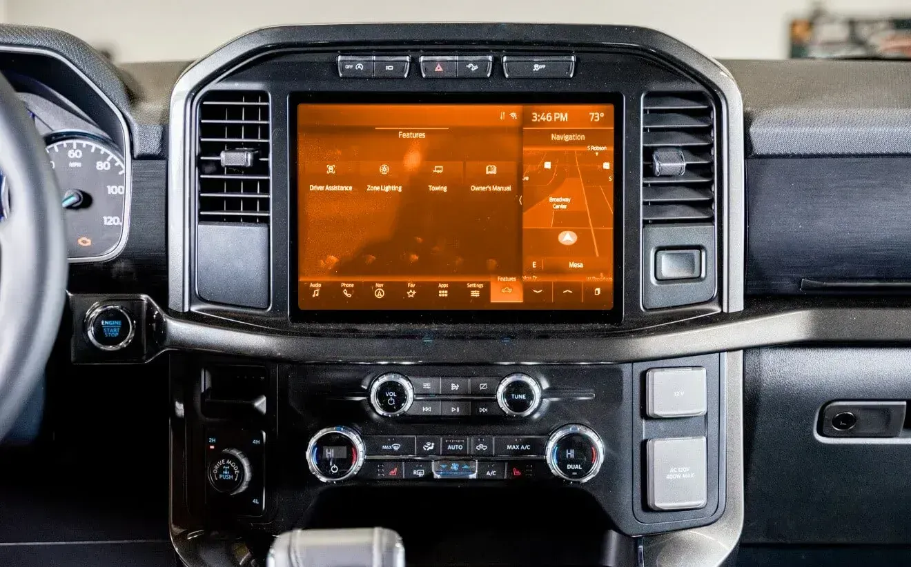 A close up of a car dashboard with a large screen