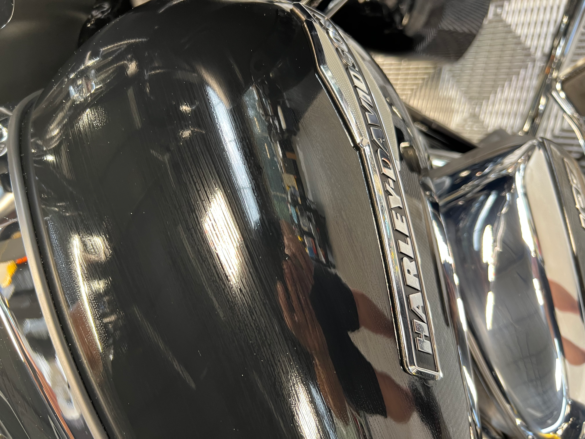 A person is working on a motorcycle with a wrench.