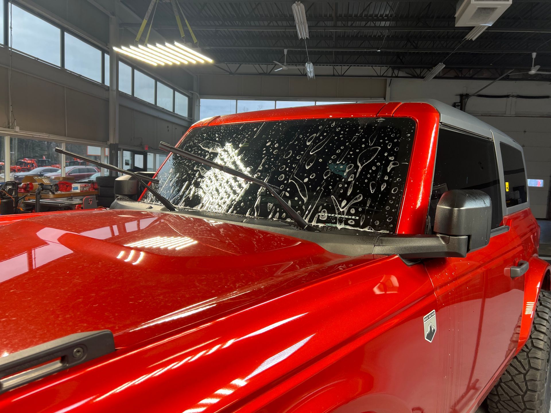 A person is wrapping a car with clear plastic