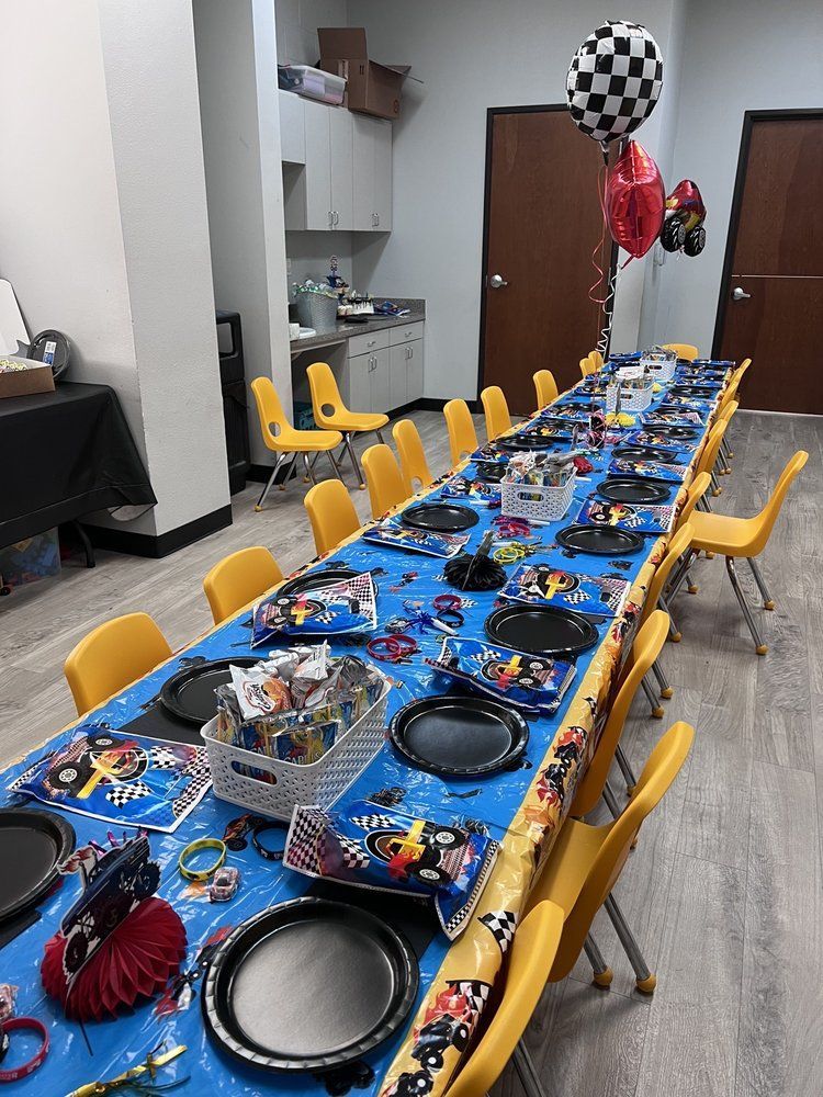 Long table set for a race car-themed party, with decorations and balloons.