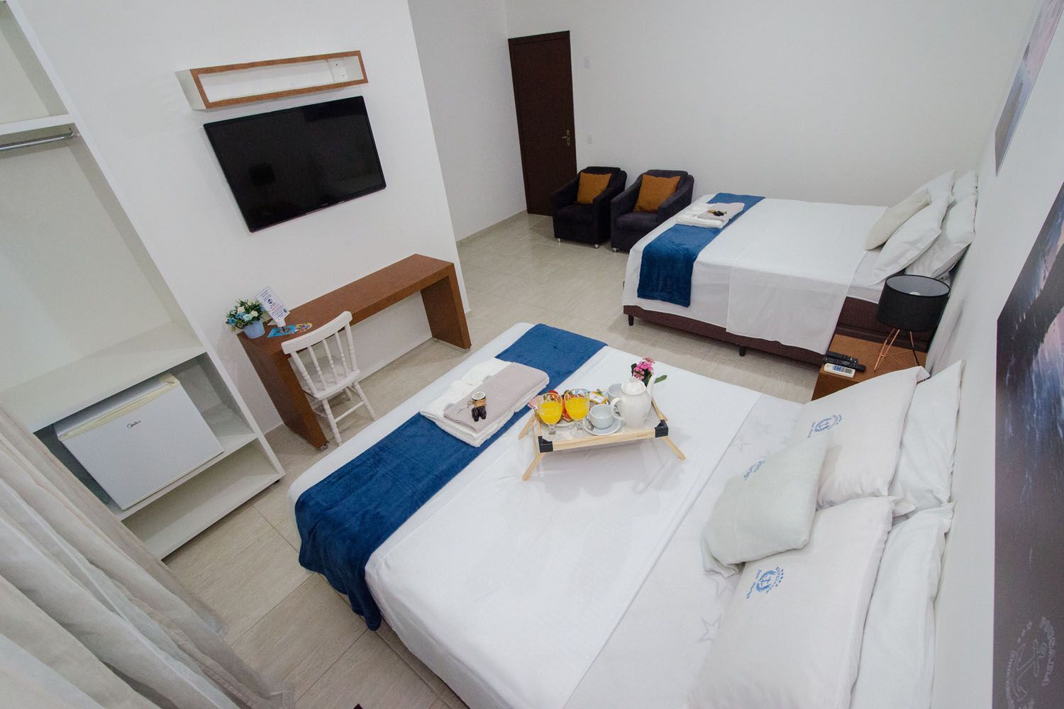 Um quarto de hotel com duas camas e uma TV de tela plana.