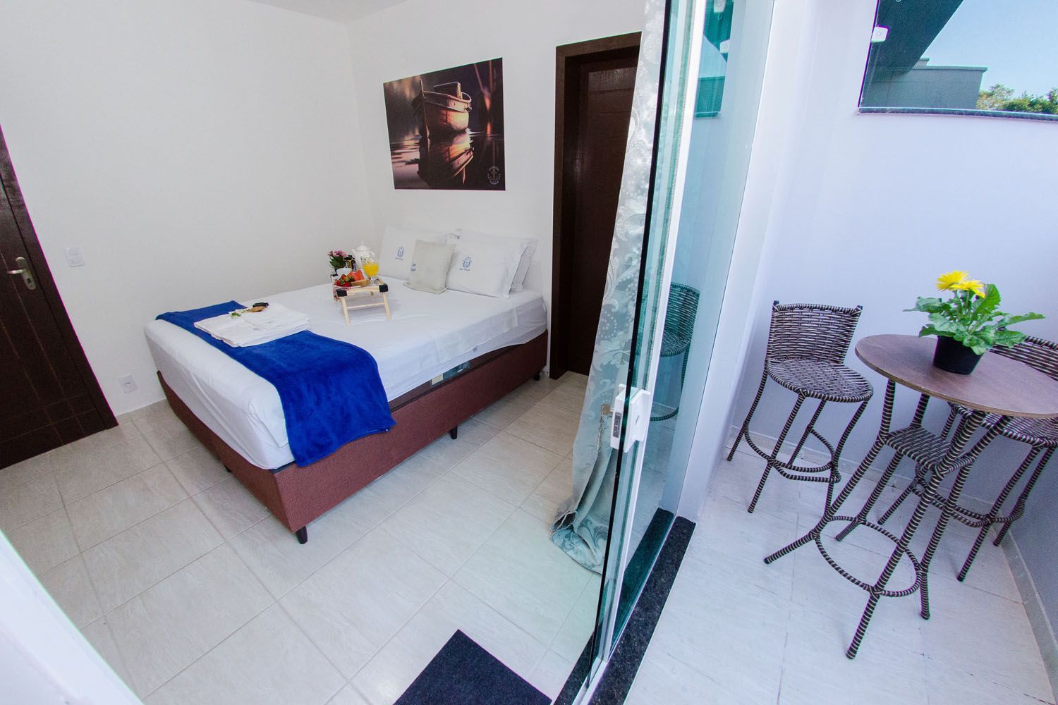 Um quarto de hotel com uma cama, mesa e cadeiras